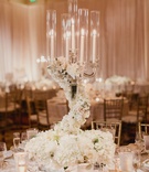 Floral-Embellished Wedding Candelabra
Photography: Shaun Menary Photography
Read More:
http://www.insideweddings.com/weddings/luxurious-hotel-wedding-texas-fair-themed-after-party-in-dallas/1241/ wedding reception crystal candelabra with swirling flowers at base white hydrangea rose flowers
