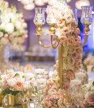 Pastel Garland on Gilt Candelabra
Photography: Chip Gillespie
Read More:
http://www.insideweddings.com/weddings/classic-jewish-wedding-at-a-synagogue-in-houston-texas/718/ Wedding reception table with gold candelabra, light orange, purple, pink roses, white hydrangeas