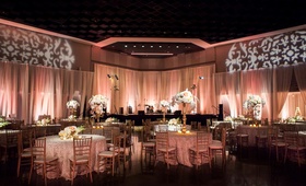 Elegant Ballroom Reception
Photography: Rob and Wynter
Read More:
http://www.insideweddings.com/weddings/a-pink-traditional-southern-wedding-at-a-civic-center-in-alabama/620/ Wedding reception with peach uplighting, white centerpieces, round tables and golden chairs