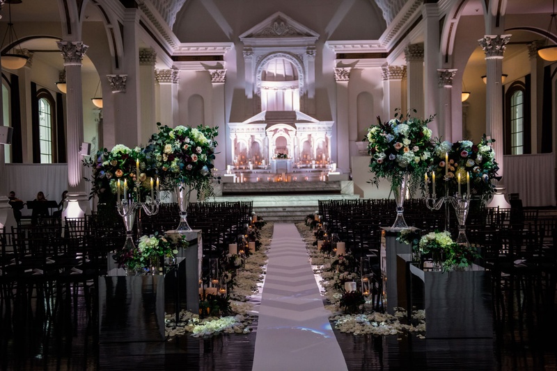 Non-Traditional Ceremony at Vibiana
Photography: Kim Fox Photography
Read More:
http://www.insideweddings.com/weddings/luxe-vintage-inspired-winter-wedding-in-downtown-los-angeles/1082/ Wedding ceremony at Vibiana altar lighting flower arrangements on risers petals along aisle runner