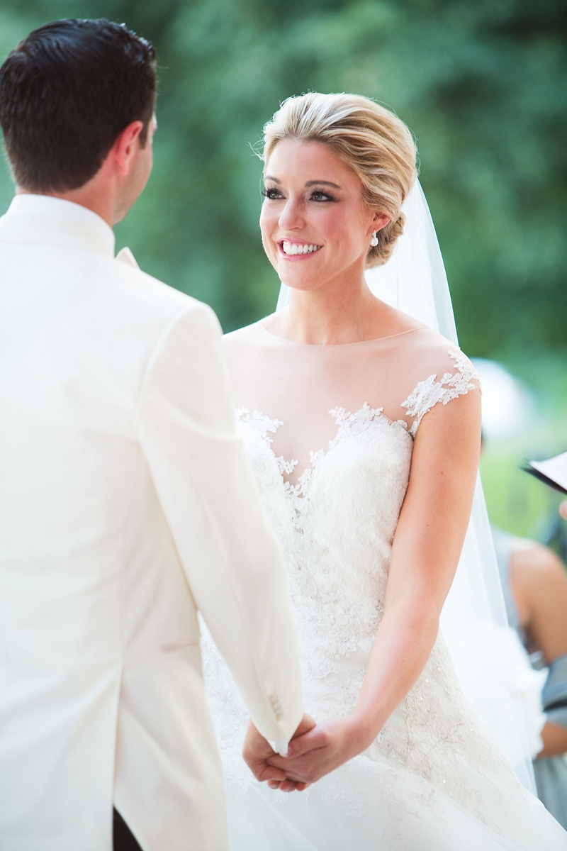 Bride Holding Groom's Hand During Service
Photography: Sarah Kate, Photographer
Read More:
http://www.insideweddings.com/weddings/outdoor-fall-ceremony-opulent-tented-reception-in-dallas-texas/1022/ Bride in illusion neckline romona keveza ball gown wedding dress holding groom's hand white tuxedo