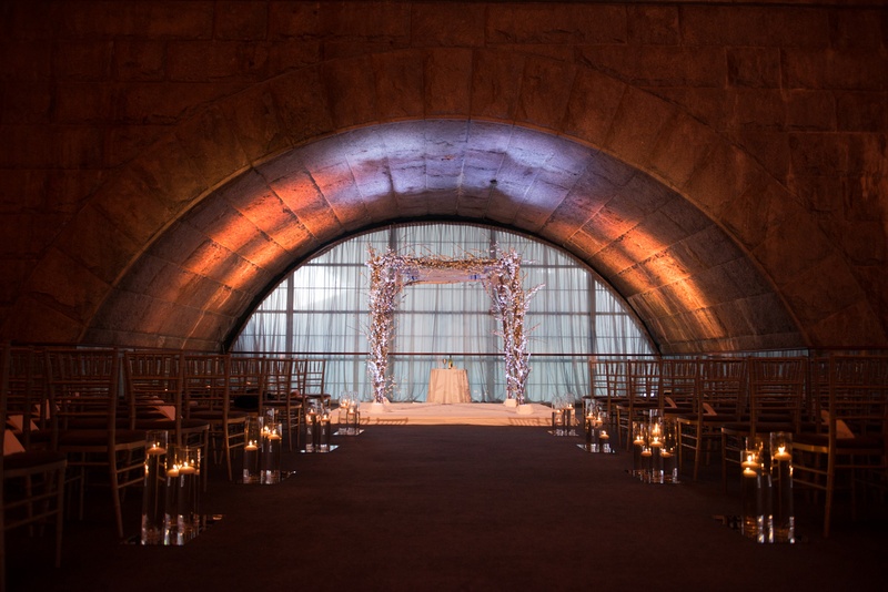 Dimly Lit Ceremony Space
Photography: Ira Lippke Studios
Read More:
http://www.insideweddings.com/weddings/chic-classic-new-york-city-wedding-with-personal-touches/783/ dimly lit ceremony space featuring a white chuppah and stage with cherry blossoms