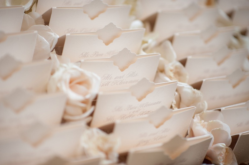 Elegant Escort Cards on Bed of Flowers
Photography: John Solano Photography
Read More:
http://www.insideweddings.com/weddings/an-opulent-garden-ceremony-ballroom-reception-in-beverly-hills/986/ Ivory escort cards with unique design and pocket by Lehr and Black beverly hills wedding