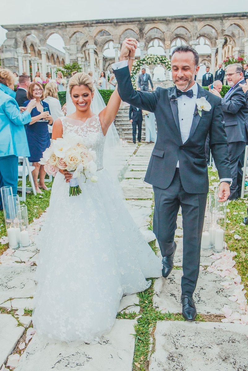 Happy Newlyweds in the Bahamas
Photography: LuvRox Photography
Read More:
http://www.insideweddings.com/weddings/luxurious-destination-wedding-at-the-ocean-club-in-the-bahamas/1324/ bride in lace a-line isabelle armstrong gown raising arm with groom after ceremony at bahamas