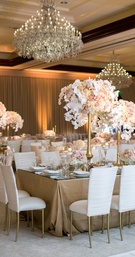 Covered White Chairs and Chandeliers
Photography: Jessica Claire Photography
Read More:
http://www.insideweddings.com/weddings/traditional-armenian-ceremony-luxurious-ballroom-reception/1006/ white covers on chiavari chairs, gold stands and floral arrangements orchids blush roses chandeliers
