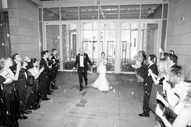 Grand Exit with Bubbles
Photography: Eric Kelley
Read More:
http://www.insideweddings.com/weddings/summer-wedding-with-clean-color-palette-modern-design-in-chicago/776/ black and white photo of bride and groom make grand exit as guests blow bubbles