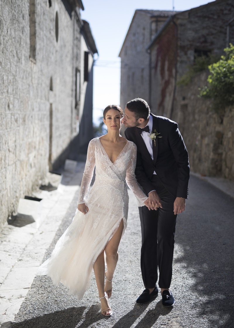 Bride and Groom Walking in Tuscany
Photography: The Day by Ira Lippke
Read More:
http://www.insideweddings.com/weddings/romantic-ceremony-on-bluff-tented-reception-in-tuscany/1311/ newlyweds walk through Italian village holding hands, groom kisses bride on the cheek