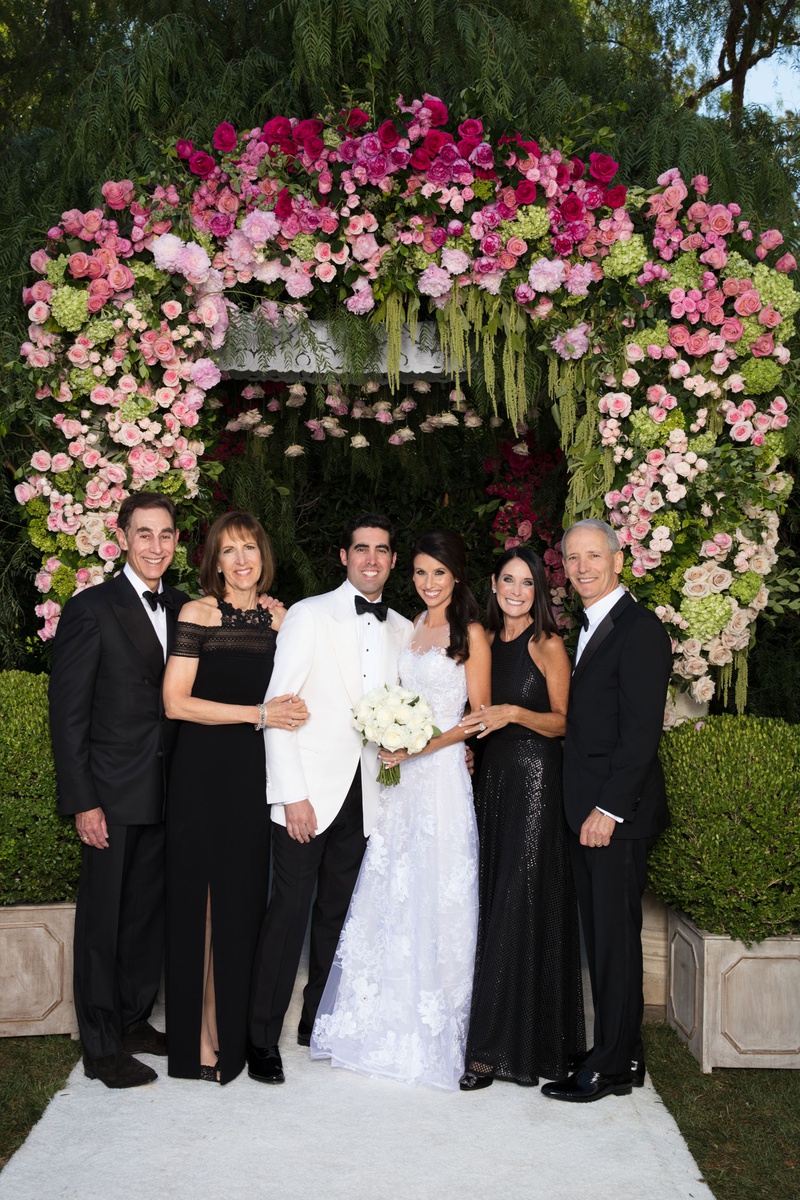 Bride %26 Groom with Family in Formalwear
Photography: Jay Lawrence Goldman Photography
Read More:
http://www.insideweddings.com/weddings/outdoor-ceremony-ballroom-reception-with-pink-flowers-greenery/1135/ Wedding portrait bride and groom in white with parents under chuppah wearing black gowns tuxes