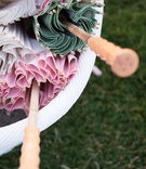 Summer Wedding Parasols
Photography: Carrie Rodman Photography
Read More:
http://www.insideweddings.com/weddings/new-england-summer-wedding-by-the-seashore/429/ White bucket filled with green, white, and pink sun-umbrellas