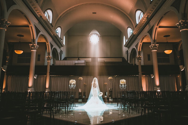 Romantic Bridal Portrait at Vibiana
Photography: Jimmy Bui Photography
Read More:
http://www.insideweddings.com/weddings/elegant-edgy-wedding-inspired-by-disney-at-vibiana-in-downtown-la/1229/ bride in wedding dress and long veil in ceremony space vibiana light streaming through window