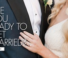 close-up of torsos with groom in navy tuxedo with black lapels and bride in beaded ivory dress