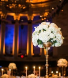 Tall White Flower Arrangement on Gold Riser
Photography: Images by Berit, Inc.
Read More:
http://www.insideweddings.com/weddings/gatsby-inspired-jewish-wedding-with-purple-gold-decor-in-new-york/720/ White rose and white hydrangea tall flower arrangement at Gotham Hall wedding reception