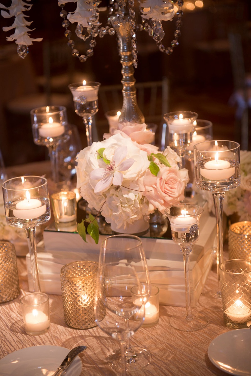 Candlelit Floral Centerpiece on Table
Photography: Boyd Harris Photographs
Read More:
http://www.insideweddings.com/weddings/a-jeweled-floral-wedding-at-fairmont-grand-del-mar-in-san-diego/745/ Rose and orchid jeweled centerpiece with candles at blush wedding reception