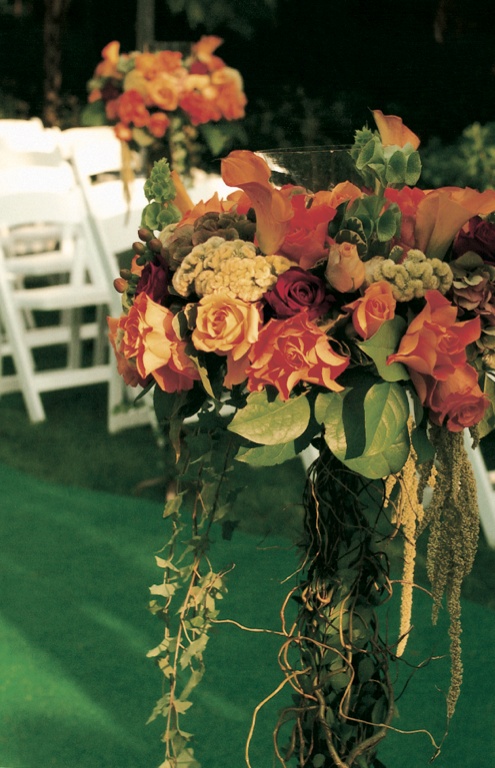 Tall Orange Floral Arrangement
Photography: Simone %26 Martin Photography
Read More:
http://www.insideweddings.com/weddings/a-midsummer-nights-dream-wedding-in-beverly-hills-california/58/ orange flowers and green leaves decorate ceremony aisle