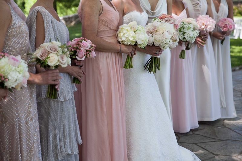Bride and Bridesmaids in Varying Pastel Dresses
Photography: Michael Bambino %26 Co.
Read More:
http://www.insideweddings.com/weddings/whimsical-open-air-secret-garden-wedding-with-soft-spring-hues/777/ a bride stands with her bridesmaids in varying styles and colors of dresses with different bouquets