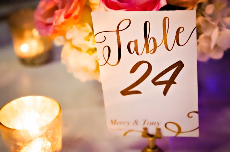 Table Number with Couple's Names
Photography: Carasco Photography
Read More:
http://www.insideweddings.com/weddings/church-ceremony-with-nigerian-traditions-chic-ballroom-reception/845/ Table in calligraphy with number and couple's names candlelight in golden votive