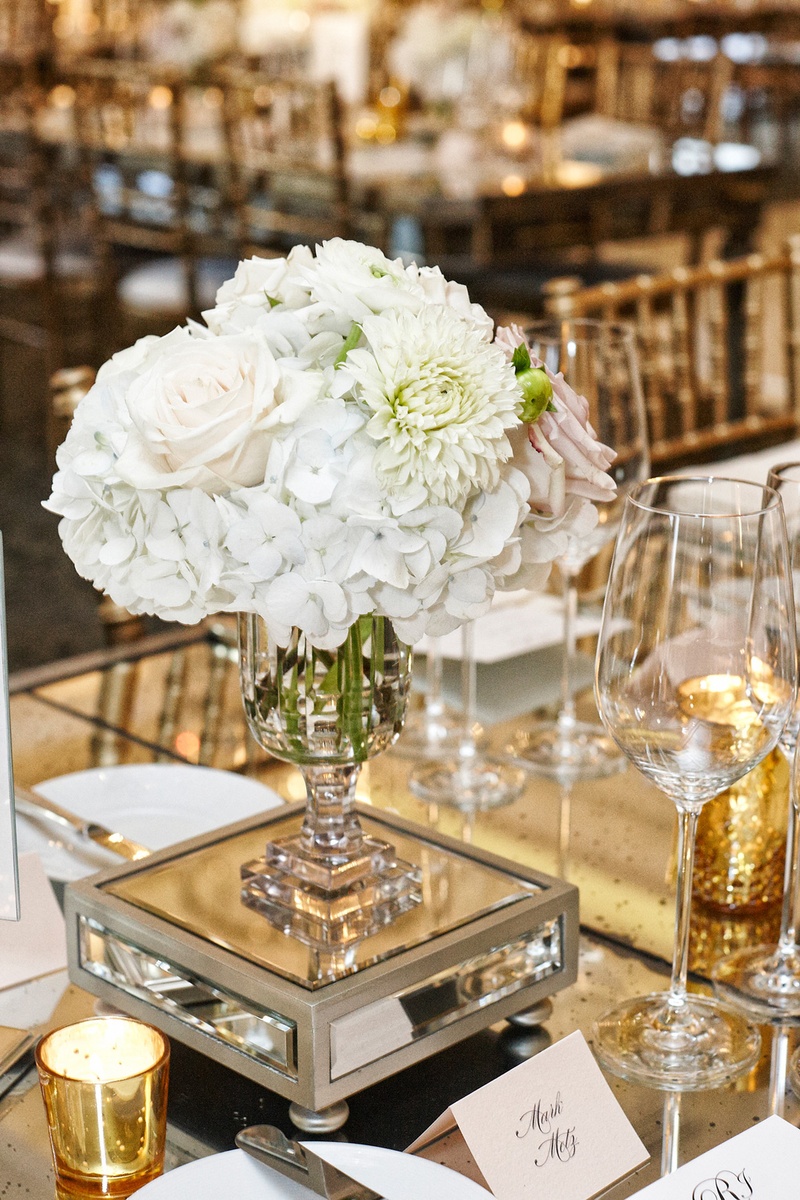 Floral Centerpiece on Mirrored Base
Photography: KingenSmith
Read More:
http://www.insideweddings.com/weddings/catholic-ceremony-soft-romantic-fairy-tale-reception-in-chicago/754/ rose, hydrangeas, and mum centerpiece in glass vase on a mirrored base