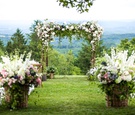 outdoor wedding ceremony with view of hudson valley white bench white pink purple flowers greenery