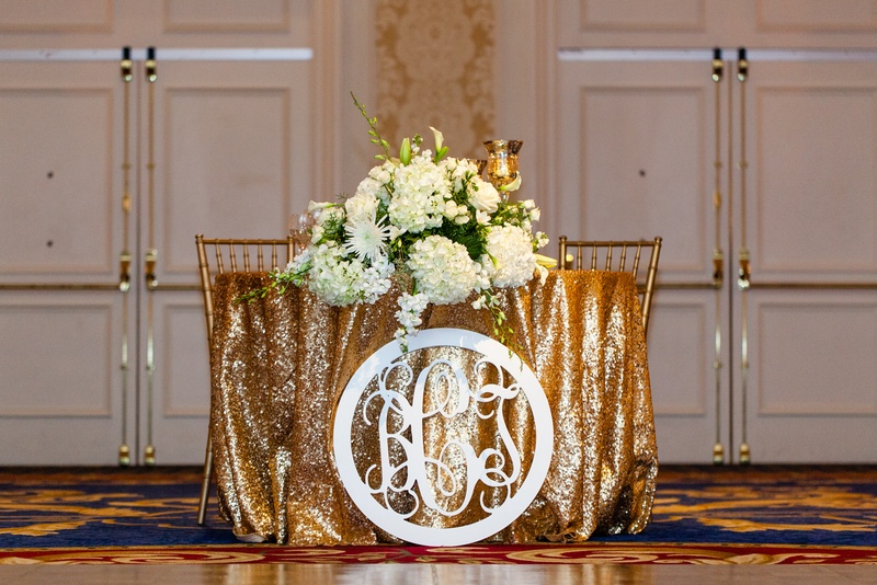 Gold Sweetheart Table
Photography: Renee Sprink Photography
Read More:
http://www.insideweddings.com/weddings/a-blue-white-gold-military-wedding-at-duke-university-chapel/622/ Gold sequin tablecloth on sweetheart table with white monogram cut out