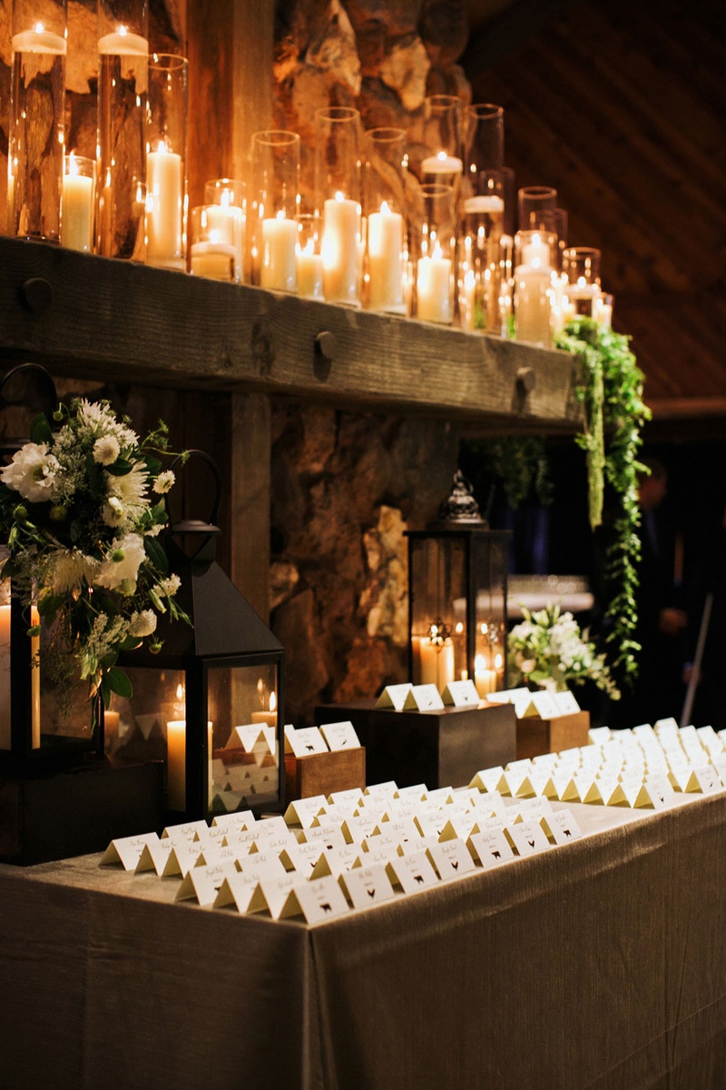 Escort Cards in Front of Candles
Photography: This Modern Romance
Read More:
http://www.insideweddings.com/weddings/rustic-chic-wedding-with-wooden-accents-and-verdant-details/861/ escort cards on table in front of lanterns and lots of candles in tall hurricanes