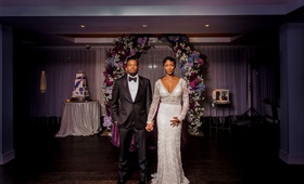 Couple in Front of Floral Display
Photography: Kesha Lambert Photography
Read More:
http://www.insideweddings.com/weddings/romantic-wedding-with-vibrant-purple-decor-and-caribbean-traditions/1138/ bride in long sleeve lace sheath dress, groom in tuxedo, newlyweds in front of floral arch