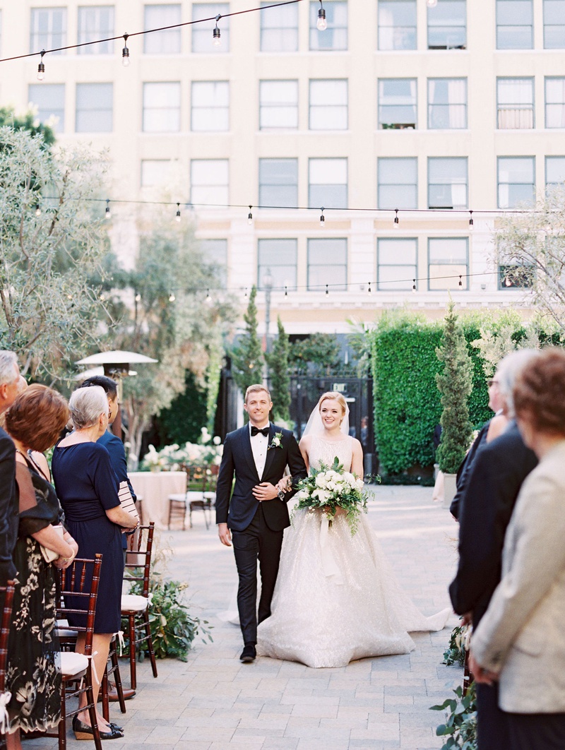 Bride Escorted Down Outdoor Aisle
Photography: Mallory Dawn Photography
Read More:
http://www.insideweddings.com/weddings/outdoor-jewish-ceremony-luxe-reception-at-vibiana-in-downtown-la/1259/ bride in high neck lazaro wedding dress escort in tuxedo bow tie bistro lights overhead vibiana