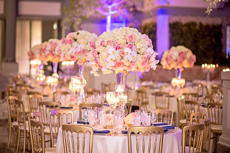 Tall Orchid, Rose, Hydrangea Arrangement
Photography: Carasco Photography
Read More:
http://www.insideweddings.com/weddings/church-ceremony-with-nigerian-traditions-chic-ballroom-reception/845/ Tall centerpiece with pink rose, white orchid, white hydrangea flowers gold chairs purple lighting
