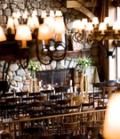 Wooden Lodge Ceremony
Photography: Kristin Spencer Photography
Read More:
http://www.insideweddings.com/weddings/producer-hilary-lefebvres-nature-inspired-wedding-in-beaver-creek/229/ lodge with wooden chairs, stone fireplace and rustic lampshade chandeliers