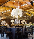 Tall Orchid Centerpiece at Barn Venue
Photography: Perez Photography
Read More:
http://www.insideweddings.com/weddings/incredible-tented-ceremony-barn-reception-at-ranch-in-aspen/860/ Aspen Colorado wedding reception in wood barn with dark linens chairs and tall white orchid flowers