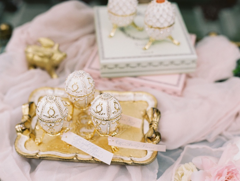 Faberge Egg Escort Cards
Photography: Abby Jiu Photography
Read More:
http://www.insideweddings.com/weddings/chic-parisian-romance-inspired-spring-wedding-in-washington-dc/1038/ Unique escort card favor combo tags with white gold eggs on bed of grey tulle
