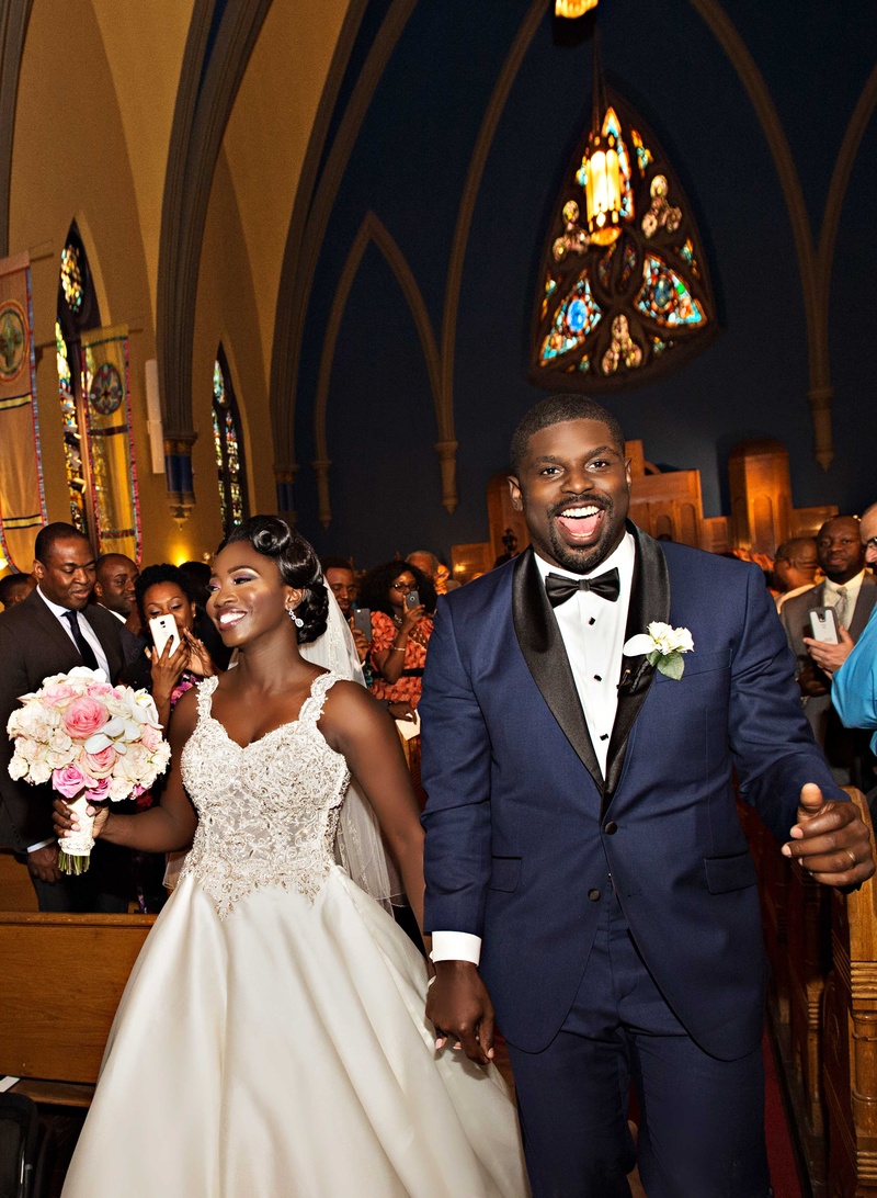 Couple Leaving Church Ceremony
Photography: Carasco Photography
Read More:
http://www.insideweddings.com/weddings/church-ceremony-with-nigerian-traditions-chic-ballroom-reception/845/ Bride and groom in navy tuxedo during recessional at Chicago church wedding ceremony