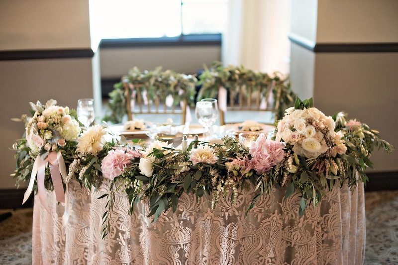 Sweetheart Table with Garland Border
Photography: Laurie Bailey Photography
Read More:
http://www.insideweddings.com/weddings/oceanfront-wedding-ceremony-classic-romantic-ballroom-reception/854/ sweetheart table, patterned linens, floral garland in front, greenery of backs of chiavari chairs