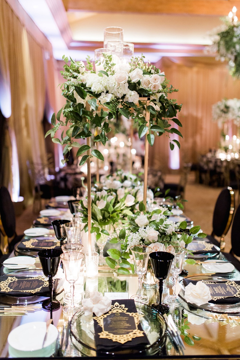 Black %26 Gold Décor on Mirrored Table
Photography: Brett Hickman Photographers
Read More:
http://www.insideweddings.com/weddings/charlise-castro-and-george-springer-iii/1165/ Gold stand on wedding table white rose hydrangea greenery candles tulip black goblet chairs menus