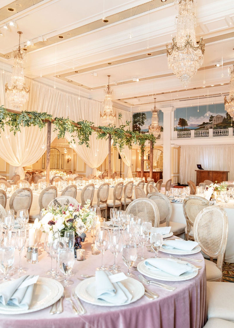 Lavender %26 Pale Blue Linens
Photography: Mantas Kubilinskas Photography
Read More:
http://www.insideweddings.com/weddings/sophisticated-ceremony-ballroom-reception-in-washington-dc/1296/ wedding reception ballroom chandelier round table lavender linen oval back wood cane chairs greenery