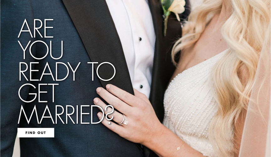 close-up of torsos with groom in navy tuxedo with black lapels and bride in beaded ivory dress