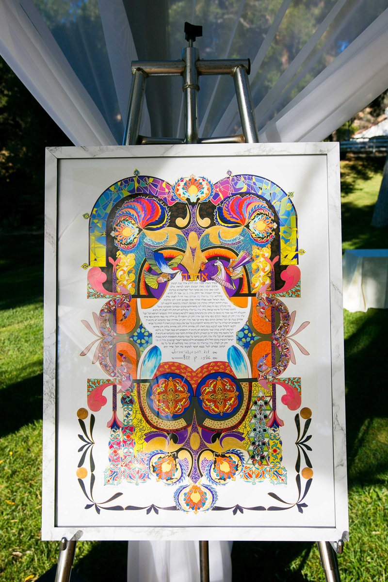 Multi-Colored Ketubah
Photography: Callaway Gable
Read More:
http://www.insideweddings.com/weddings/alfresco-summer-wedding-with-lush-foliage-accents-in-california/805/ a brightly colored ketubah displayed at couples traditional jewish ceremony