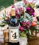Table Number on Wine Bottle
Photography: Amanda McKinnon Photography
Read More:
http://www.insideweddings.com/weddings/bride-wears-claire-pettibone-gown-to-bohemian-outdoor-wedding/668/ Outdoor bohemian wedding reception table with table number on wine bottle label, votive candles