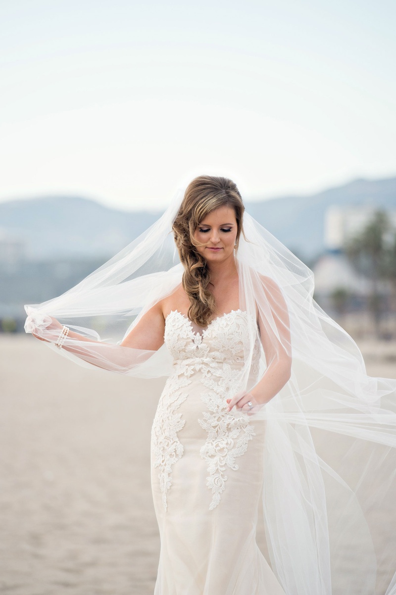 Bride with Veil on Beach
Photography: Laurie Bailey Photography
Read More:
http://www.insideweddings.com/weddings/classic-church-ceremony-soft-romantic-reception-in-santa-monica/978/ Bride in Ines Di Santo wedding dress playing with veil on beach hair to side windy day Santa Monica