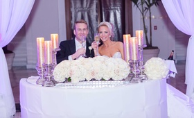 Newlyweds Toast at Sweetheart Table
Photography: Travis Harris Photography
Read More:
http://www.insideweddings.com/weddings/romantic-wedding-with-ivory-champagne-gold-palette-in-florida/709/ Bride in strapless dress, rhinestone head band toasts with groom in a black tux, white tie at table