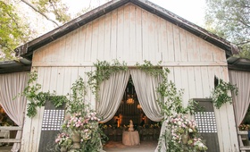 Wood Barn Venue in Santa Barbara
Photography: Samuel Lippke Studios
Read More:
http://www.insideweddings.com/weddings/a-rustic-camp-themed-outdoor-wedding/908/ White wash wood barn with drapery greenery wood boards with escort cards for reception