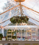 Verdant Chandelier with String Lights and Bar
Photography: Vue Photography
Read More:
http://www.insideweddings.com/weddings/snowy-winter-wedding-at-the-grooms-family-home-in-south-carolina/969/ tent wedding, string lights, greenery chandelier, bar