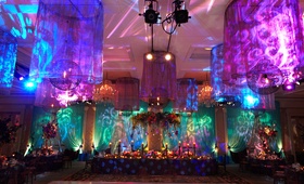 Colorful, Patterned Lighting at Reception
Photography: KingenSmith
Read More:
http://www.insideweddings.com/weddings/colorful-ballroom-wedding-in-chicago-with-enchanted-forest-theme/820/ purple, blue, and teal uplighting with projected patterns