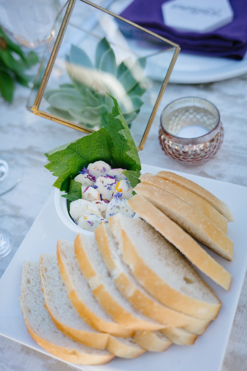 Bread with Flower-Infused Butter
Photography: Karlisch Photography
Read More:
http://www.insideweddings.com/weddings/modern-rustic-wedding-full-of-flowers-and-geometric-details/906/ slices of sourdough bread with butter mixed with flower petals edible flowers