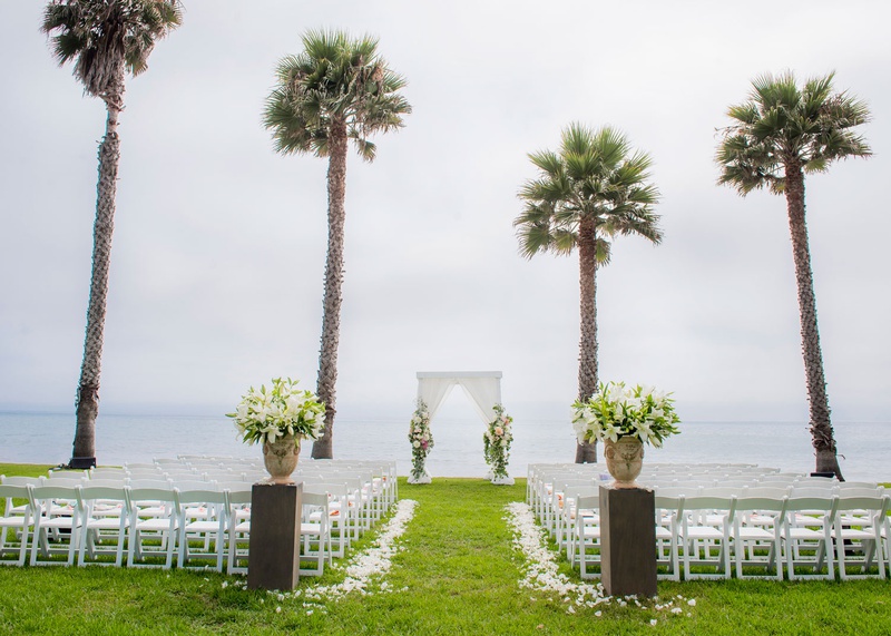 Ocean-View Ceremony with Palm Trees
Photography: Willa Kveta Photography
Read More:
http://www.insideweddings.com/weddings/alfresco-ceremony-by-the-beach-elegant-barn-wedding-reception/1298/ wedding ceremony on grass lawn overlooking beach ocean palm trees lily flowers in stone urn drapery