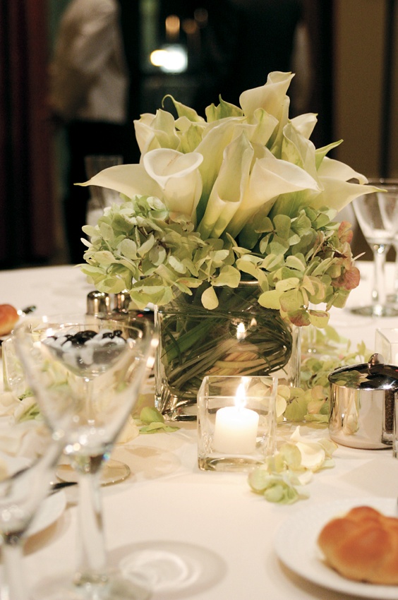 White and Green Centerpiece
Photography: Karen French Photography
Read More:
http://www.insideweddings.com/weddings/romantic-winter-wedding-in-huntington-beach-california/81/ Calla lily and hydrangea filling glass vase