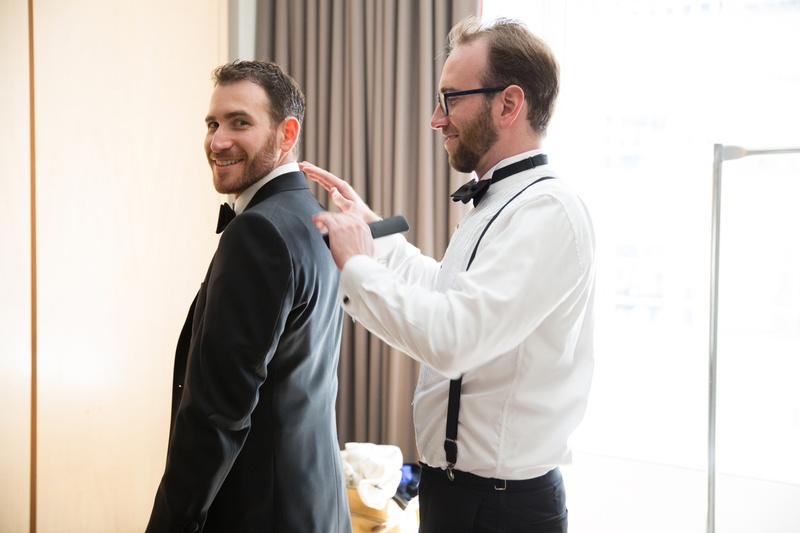 Groom and Groomsman Getting Ready
Photography: Ira Lippke Studios
Read More:
http://www.insideweddings.com/weddings/chic-classic-new-york-city-wedding-with-personal-touches/783/ a groomsman helps the groom put on his suit jacket before the ceremony