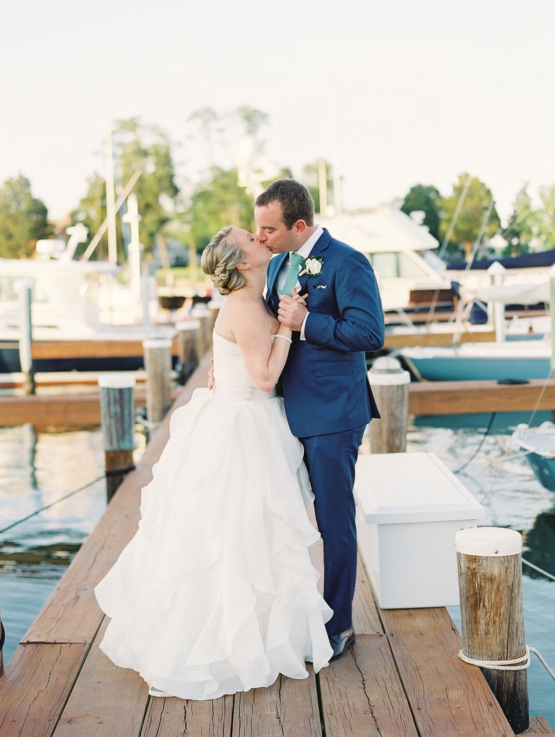 Bride %26 Groom Kiss on Dock
Photography: Bonnie Sen Photography
Read More:
http://www.insideweddings.com/weddings/outdoor-ceremony-tented-reception-by-a-tranquil-river-in-maryland/1088/ Bride in strapless ball gown kisses groom in navy blue suit and green tie on wood dock wedding venue
