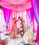 Bride Places Flower Garland Around Groom's Neck
Photography: Alucinarte Films
Read More:
http://www.insideweddings.com/weddings/vibrant-indian-wedding-with-purple-details-in-new-york-city/815/ pink and purple hindu wedding ceremony, bride places flower garland around groom's neck
