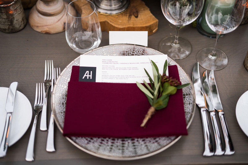 Burgundy Napkin at Guest Place Setting
Photography: Samuel Lippke Studios
Read More:
http://www.insideweddings.com/weddings/tuscany-meets-rustic-california-outdoor-wedding-under-the-stars/1336/ wedding reception grey wash wood table wood plank riser burgundy napkin sprig of greenery silver