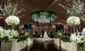 Tented Ballroom Ceremony
Photography: KingenSmith
Read More:
http://www.insideweddings.com/weddings/luxe-jewish-wedding-with-personal-details-greenery-chinoiserie/1152/ Bride and groom on circle stage chuppah greenery flower chandelier white rose hedge wall topiary